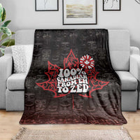 Black blanket with red Canada 'from Eh to Zed' design on sofa