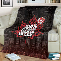 Black throw blanket draped on couch, red emblem and white flower print