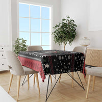 Black tablecloth with red and white festive trim and Krampus characters across top