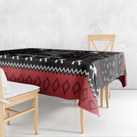 Black Christmas tablecloth with red diamond pattern and Krampus figures along draped edge