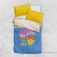 Blue duvet cover set with two yellow pillowcases; colorful island graphic and stripe detail