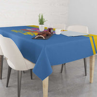 Blue tablecloth draped over dining table with colorful island artwork center