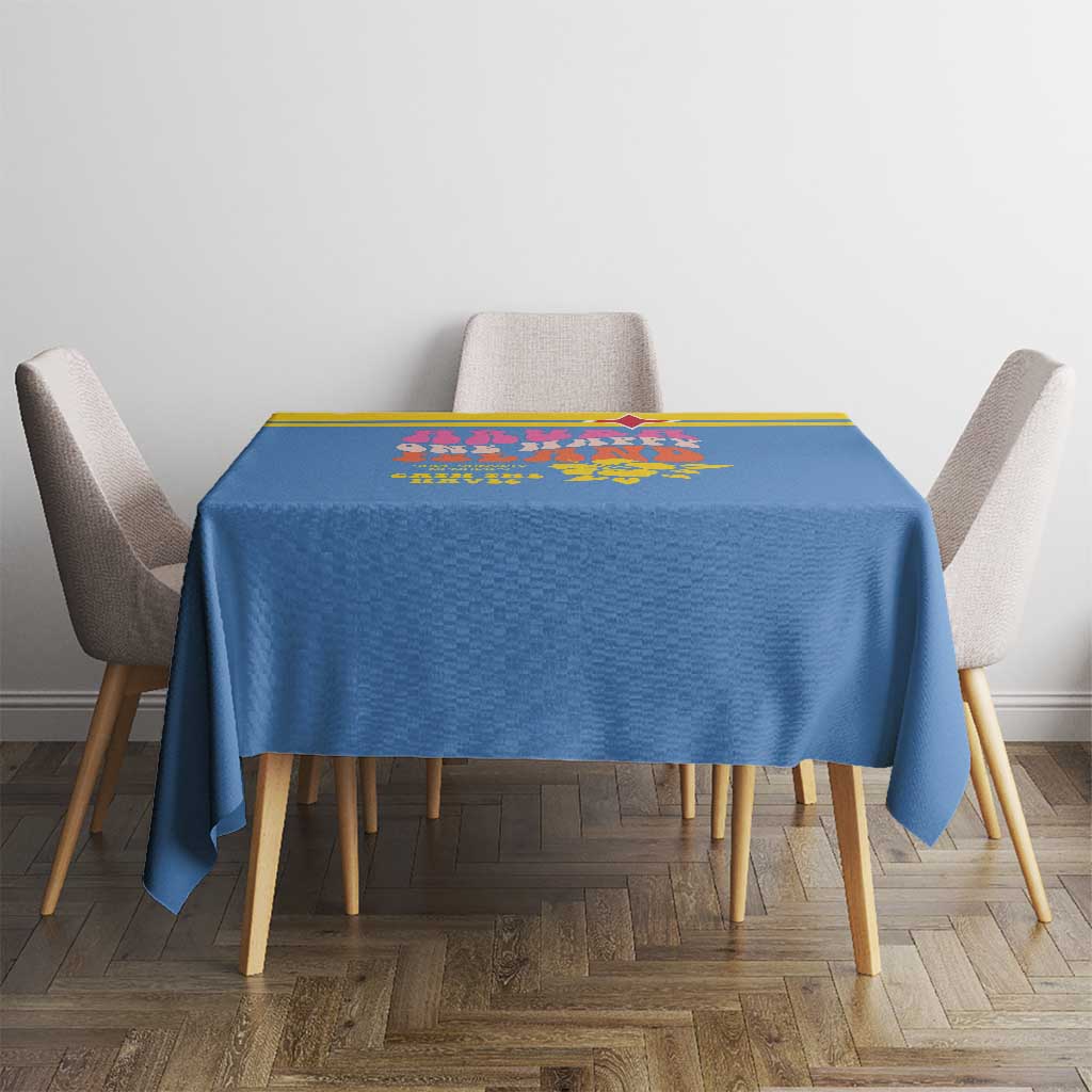 Blue square tablecloth with yellow border and colorful island print on table