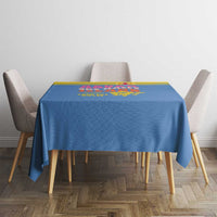 Blue square tablecloth with yellow border and colorful island print on table