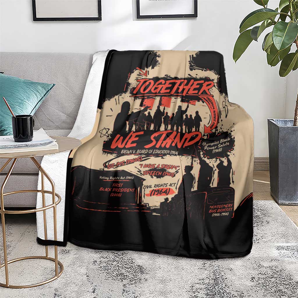 Together We Stand blanket in black and tan with red lettering, displayed on a living room chair
