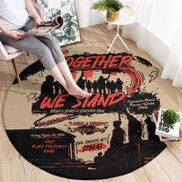 Round graphic carpet on floor, beige with black silhouettes and red Together We Stand lettering