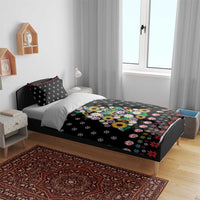 Black duvet cover on a bed with peace-sign flower tree design and red Christmas borders.