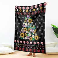 Black blanket featuring peace signs, flowers, and Christmas tree scene with red accents
