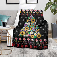 Black blanket with colorful flowers, peace symbols, and Christmas tree artwork on front