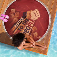 Red round beach blanket with white fringe, diagonal 'Justice To The People' text with fists