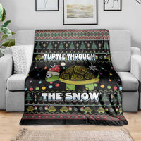Black holiday throw blanket with turtle and snowflake border on sofa