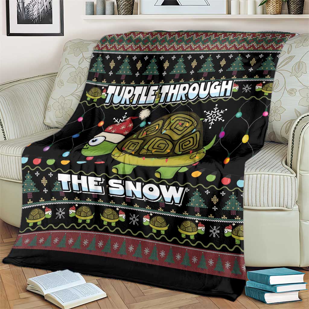 Black holiday throw blanket with turtle and snow typography on couch