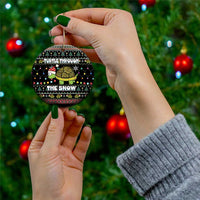 Round black ceramic Christmas ornament with turtle graphic and “TURTLE THROUGH THE SNOW” lettering.
