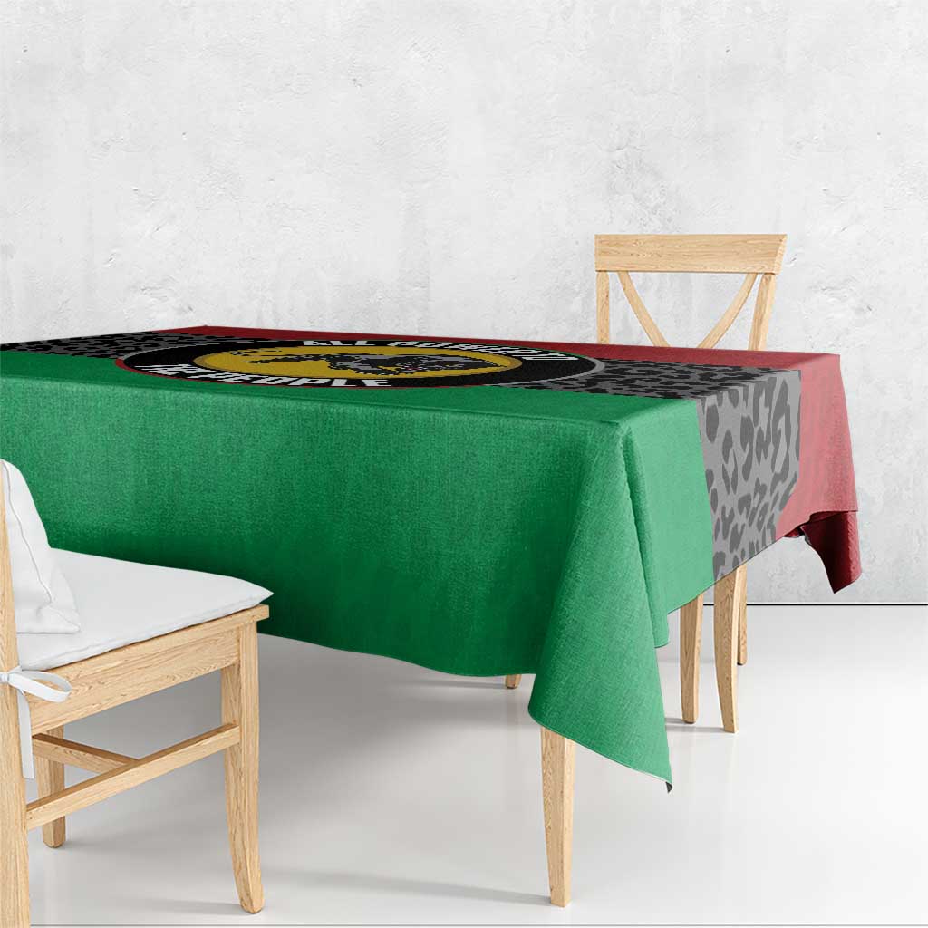 Panther tablecloth on table with green fabric, black leopard pattern, and red border