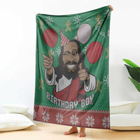 Green blanket featuring cartoon Jesus portrait with balloons and red holiday lettering