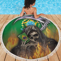 Round green beach blanket with reaper skull graphic, white fringe, draped on person