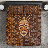 Brown mudcloth-style bedding set with bold geometric border and tribal face graphic.