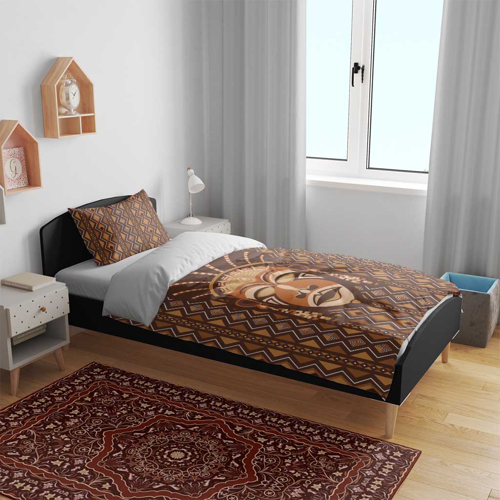 Brown tribal face printed duvet cover with geometric border on bed, shown with pillowcases.