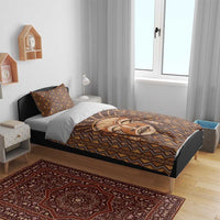 Brown tribal face printed duvet cover with geometric border on bed, shown with pillowcases.