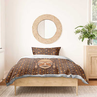 Brown mudcloth bedding set on single bed: duvet and pillowcases with tribal face motif.