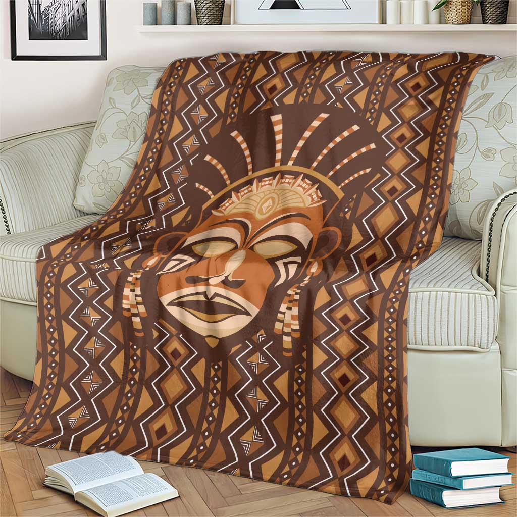 Brown printed blanket featuring tribal face portrait with diamond zigzag trim.