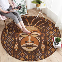 Brown round area rug with central lion mask print and zigzag geometric motifs