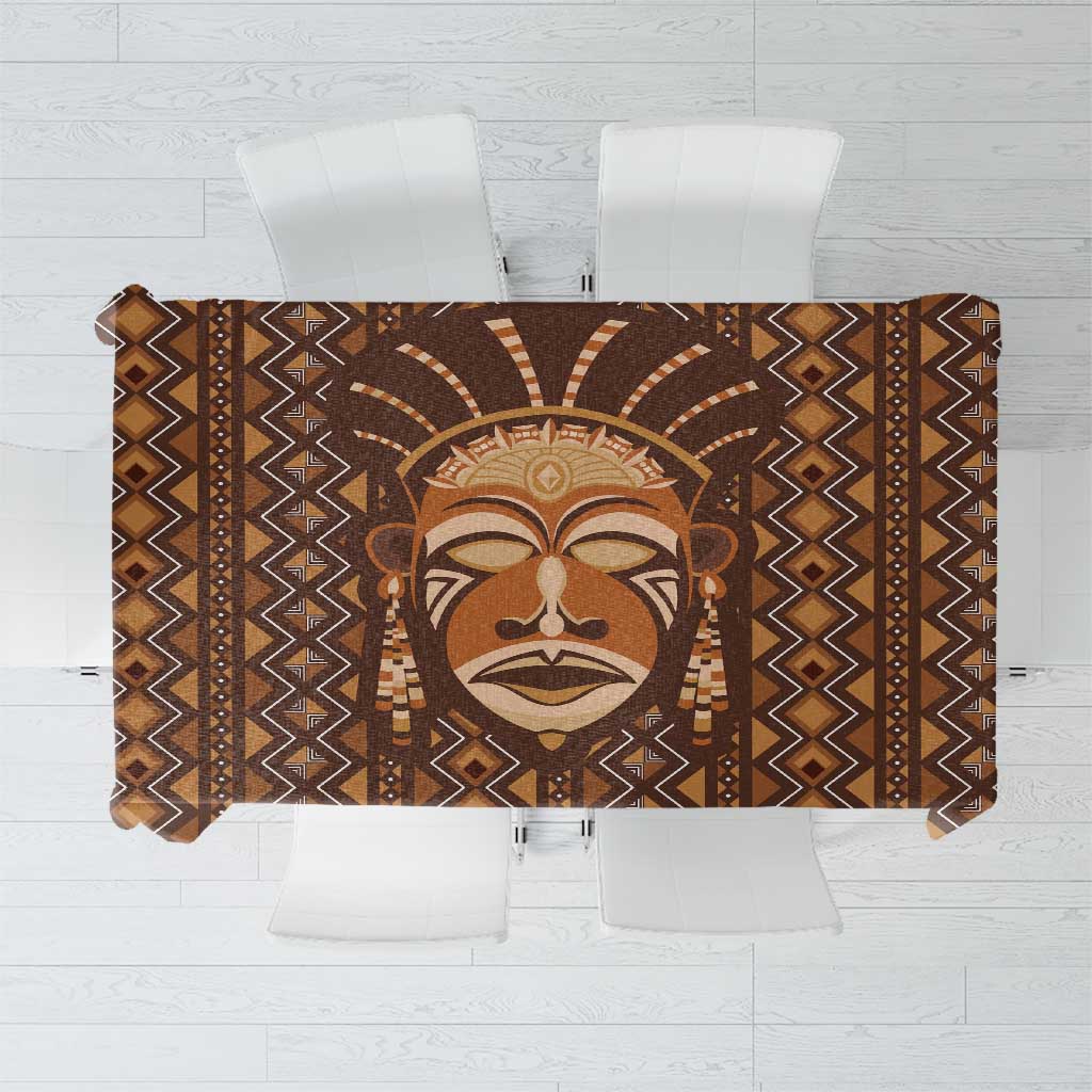 Brown mudcloth-style tablecloth with central mask and zigzag geometric borders
