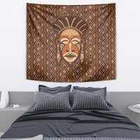 Mudcloth-style tapestry featuring a tribal mask face with sunburst headdress and geometric stripes