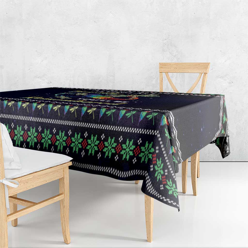 Dark tablecloth draped over wooden table with green red patterned border