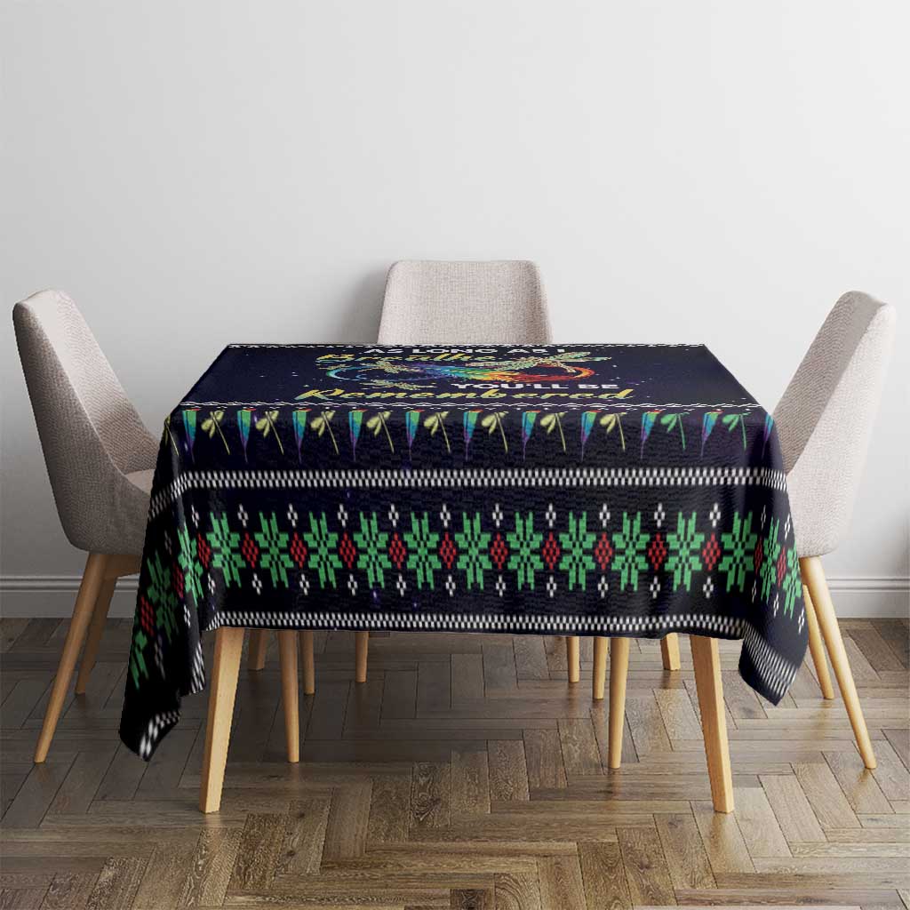 Black tablecloth with multicolor patterned border and central angel graphic on dining setup