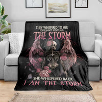 Black skeleton rose wings blanket with pink headline text, laid on gray sofa