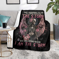 Black skeleton rose wings blanket with pink 'I Am The Storm' text, on gray floor blanket