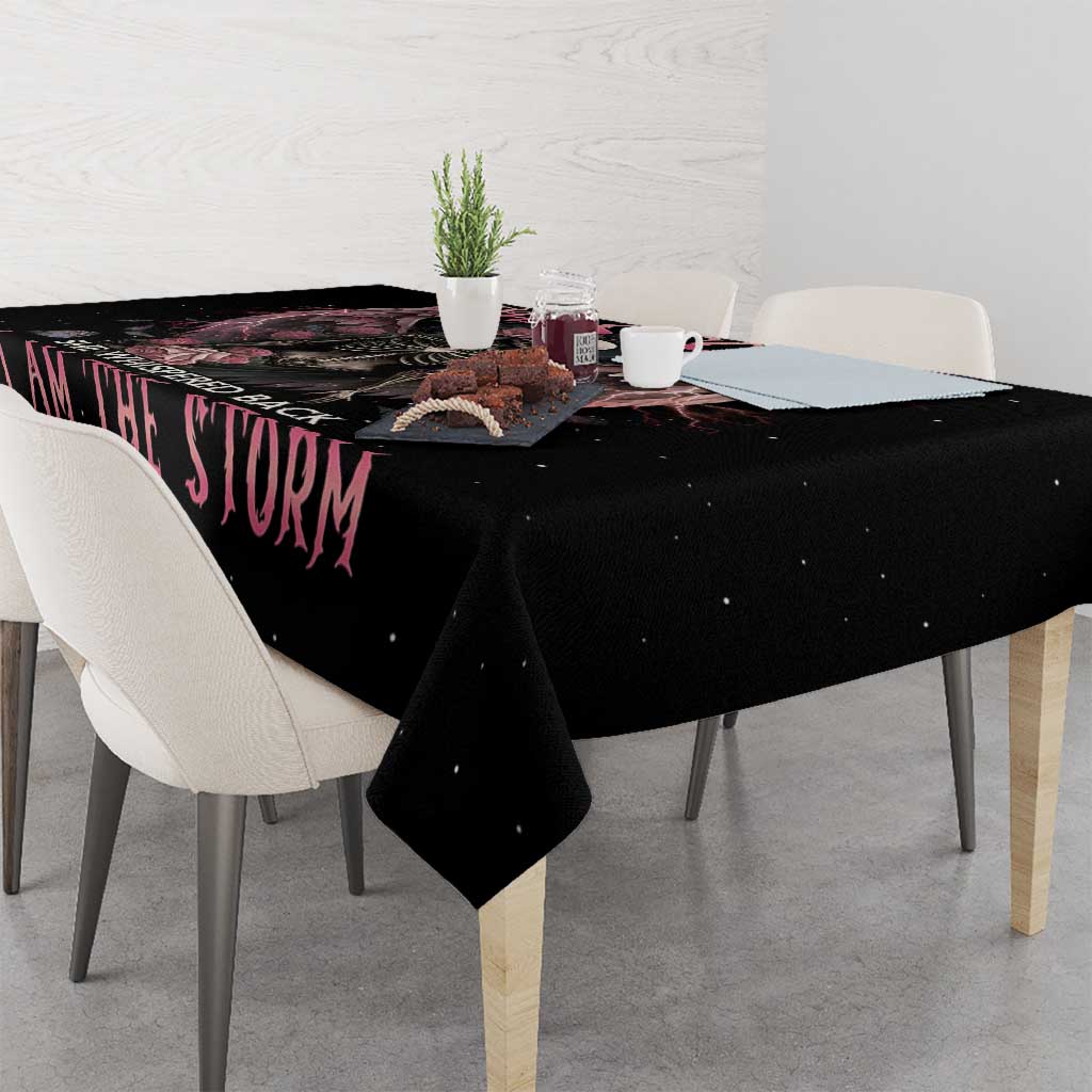 Black tablecloth draped on dining table corner with pink 'I AM THE STORM' text