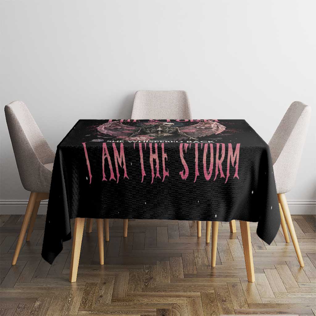Black tablecloth with pink 'I AM THE STORM' text on dining table between gray chairs