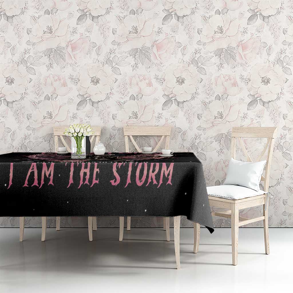 Black tablecloth with pink 'I AM THE STORM' text on dining table
