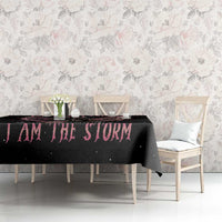 Black tablecloth with pink 'I AM THE STORM' text on dining table