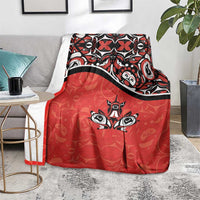 Red throw blanket on floor with black-and-white maple leaf tattoo design