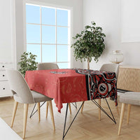 Red tablecloth with Haida-style maple leaf tattoo pattern, draped over dining table
