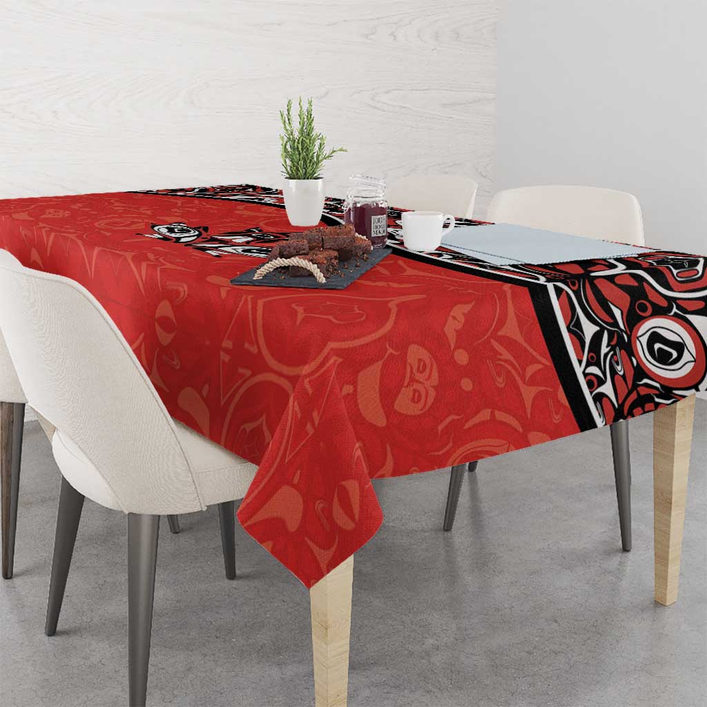 Red tablecloth with Haida-style tattoo border and maple leaf motifs on rectangular table