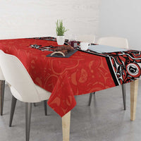 Red tablecloth with Haida-style tattoo border and maple leaf motifs on rectangular table