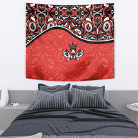 Red tapestry showing a black-and-white maple leaf emblem with decorative Haida-style accents