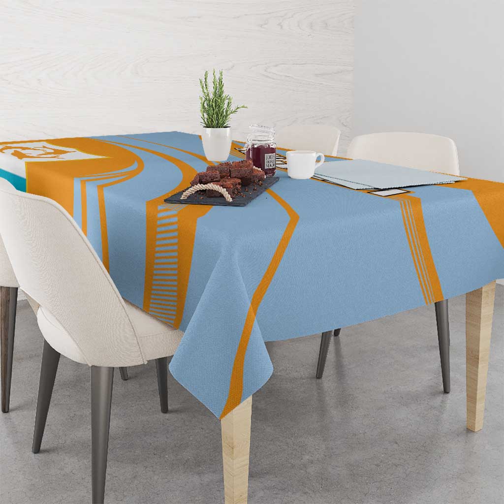 Blue and orange tablecloth draped on dining table with coat of arms crest
