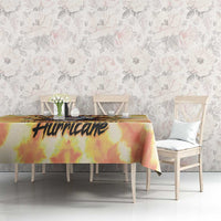 Yellow tie-dye tablecloth with black 'Hurricake' word print on a dining table