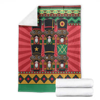 Nutcracker character blanket with red plaid center and green border, shown folded