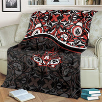 Black blanket with red and white Haida-style tribal pattern and maple leaf motif