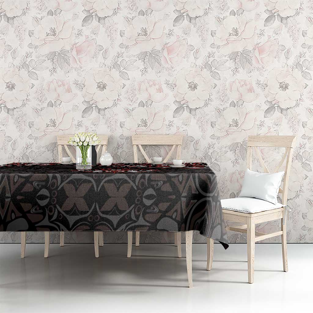 Black tablecloth with red and white Haida maple leaf tattoo design, draped on table