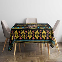 Christmas tablecloth on square table with dark base, yellow motifs, and blue stripe accents