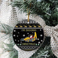 Black ceramic round Christmas ornament close-up with yellow tractor and Santa, “I’M DIGGING CHRISTMAS”