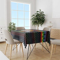 Black rectangular tablecloth with colorful stripe accents and repeating holiday pattern.