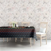 Black tablecloth with colorful festive border and dotted geometric pattern on dining table.